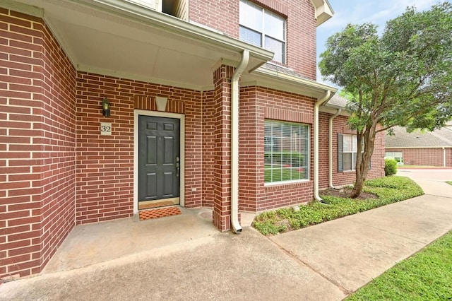doorway to property featuring brick siding