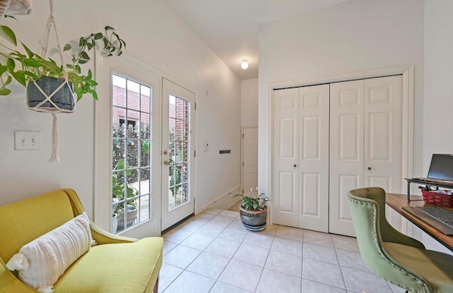 interior space featuring light tile patterned flooring, vaulted ceiling, baseboards, and french doors