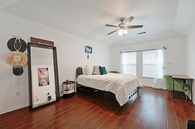bedroom with a tray ceiling, visible vents, a ceiling fan, and hardwood / wood-style flooring