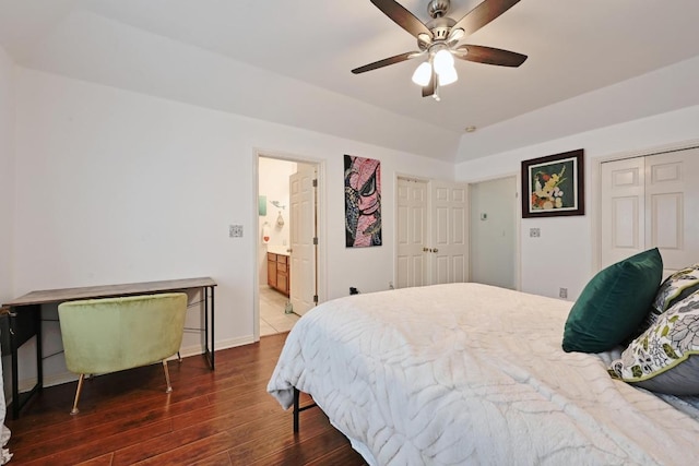 bedroom with wood finished floors, a closet, ceiling fan, baseboards, and ensuite bath