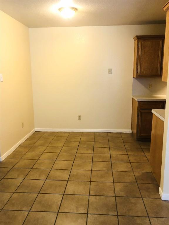 unfurnished dining area featuring tile patterned flooring and baseboards