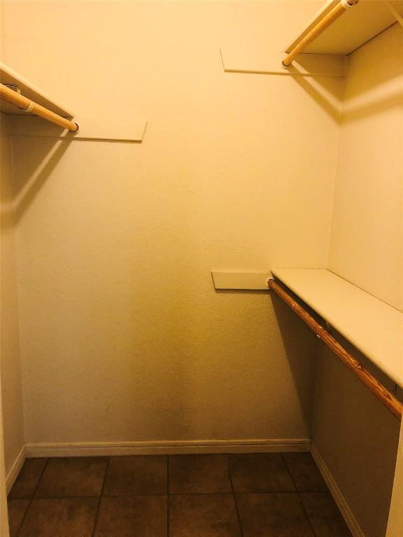 walk in closet with dark tile patterned floors