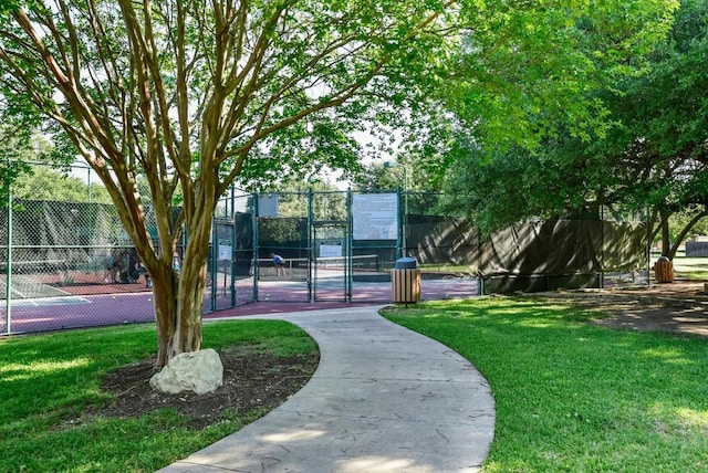 view of property's community with a tennis court and a gate
