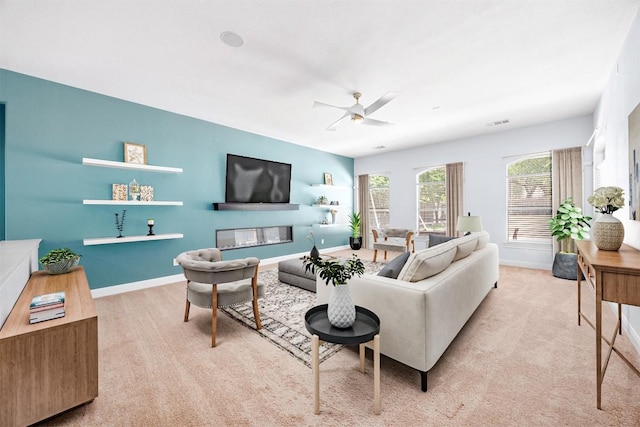 carpeted living room featuring a ceiling fan and baseboards