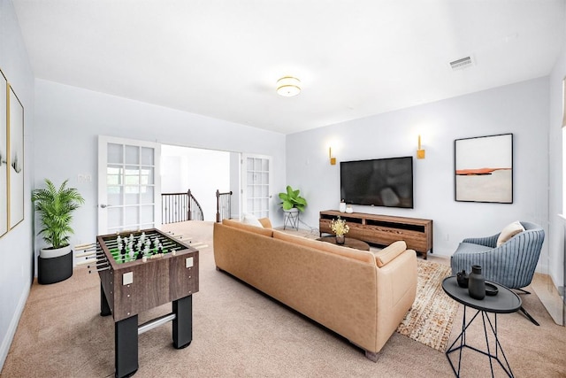 living area featuring light colored carpet and baseboards