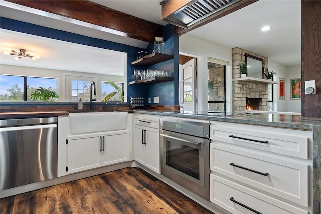 67 Augusta Dr, Wimberley, TX 78676 - kitchen with appliances with stainless steel finishes, a sink, white cabinetry, dark wood-type flooring, and recessed lighting