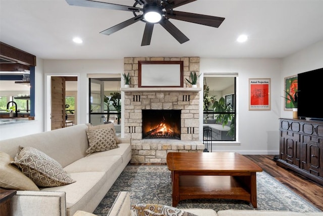 67 Augusta Dr, Wimberley, TX 78676 - living area with wood finished floors, a stone fireplace, ceiling fan, baseboards, and recessed lighting