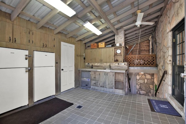 interior space featuring lofted ceiling with beams, a ceiling fan, a sink, and light tile patterned floors