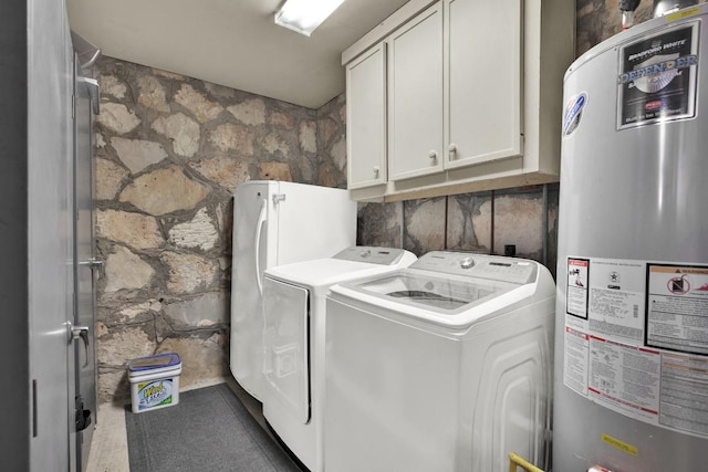 washroom featuring water heater, independent washer and dryer, and cabinet space