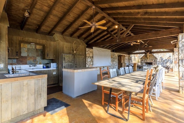 kitchen with concrete flooring, vaulted ceiling with beams, wooden ceiling, and a ceiling fan