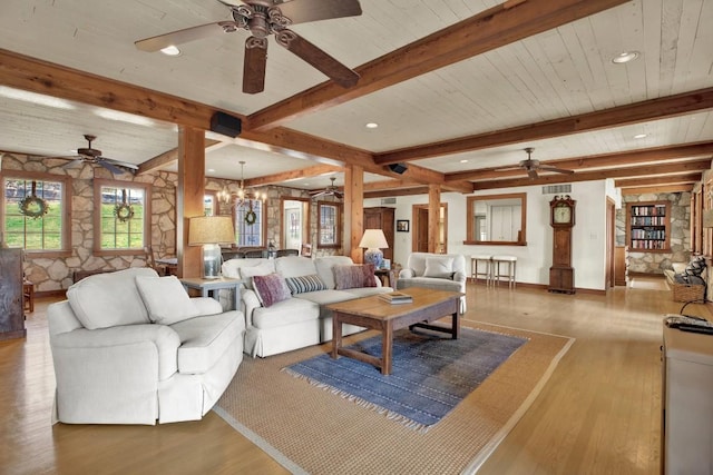 living room with ceiling fan with notable chandelier, wood finished floors, beam ceiling, and visible vents