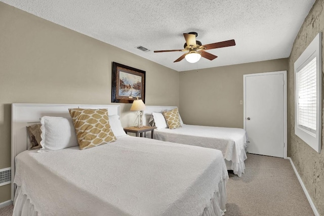 bedroom with light carpet, baseboards, visible vents, and a textured ceiling