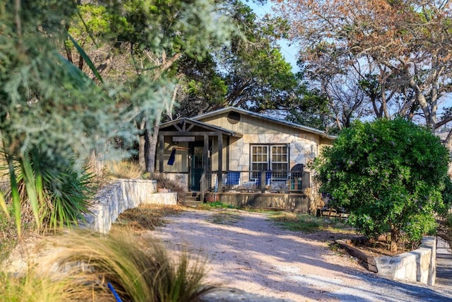 bungalow-style house with a porch and stone siding