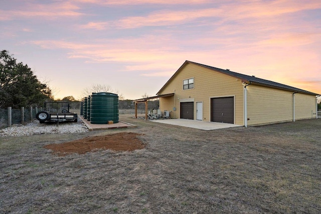 view of property exterior with fence, a patio, and a garage