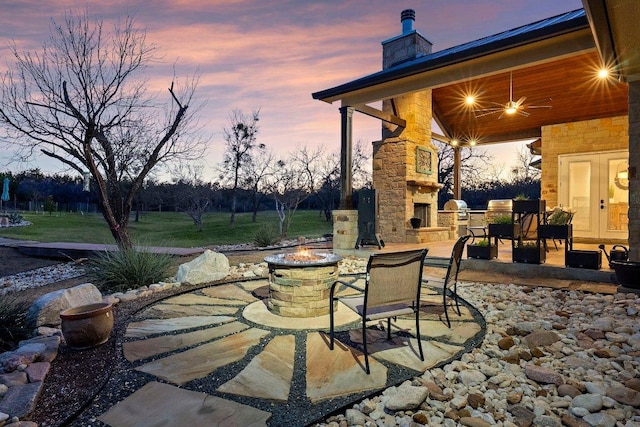 view of patio / terrace with an outdoor stone fireplace, a fire pit, and a grill