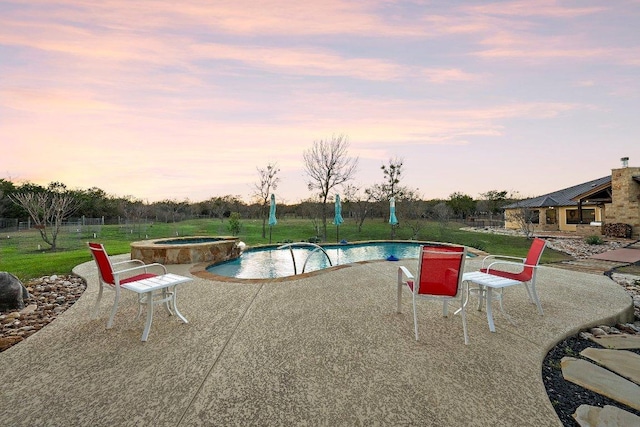 view of swimming pool featuring a lawn, fence, a patio, and a pool with connected hot tub