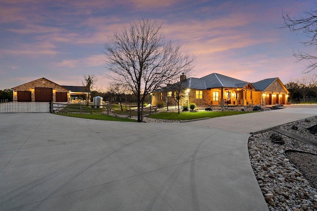 single story home featuring a gate, a fenced front yard, a chimney, driveway, and a yard