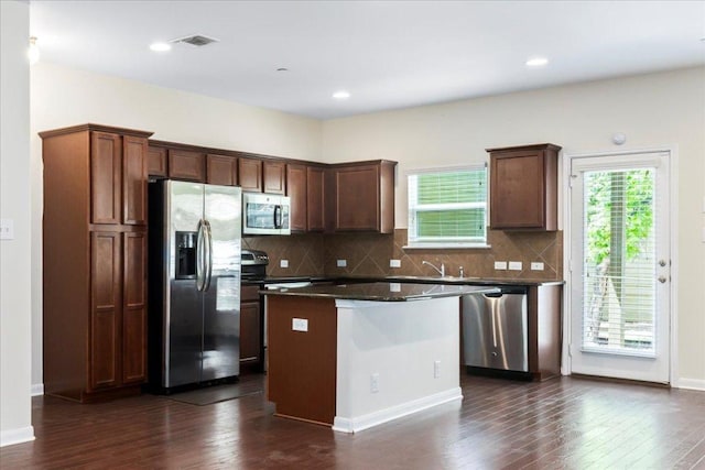 608 Lookout Tree Ln, Round Rock, TX 78664 - kitchen with dark countertops, visible vents, dark wood-type flooring, a kitchen island, and appliances with stainless steel finishes