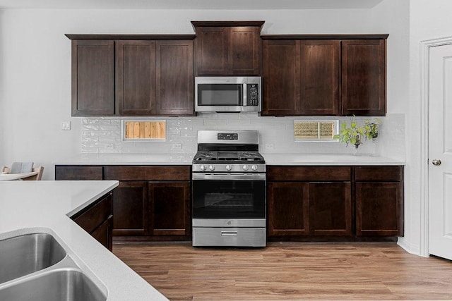 12207 Coronilla Bnd, Austin, TX 78748 - kitchen with backsplash, light countertops, stainless steel appliances, and light wood-type flooring