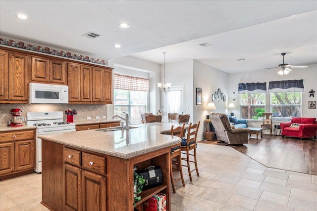 719 Walsh Hill Trl, Cedar Park, TX 78613 - kitchen with white appliances, a sink, brown cabinetry, open floor plan, and recessed lighting