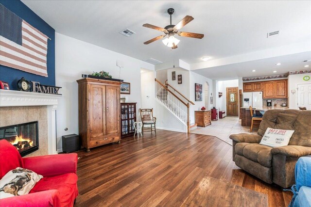 719 Walsh Hill Trl, Cedar Park, TX 78613 - living room featuring stairs, ceiling fan, wood finished floors, a tiled fireplace, and recessed lighting