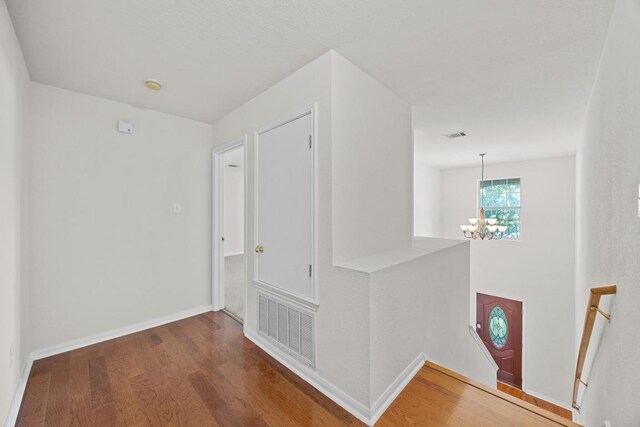 1444 Newbury St, Georgetown, TX 78626 - corridor featuring a chandelier, an upstairs landing, wood finished floors, and baseboards