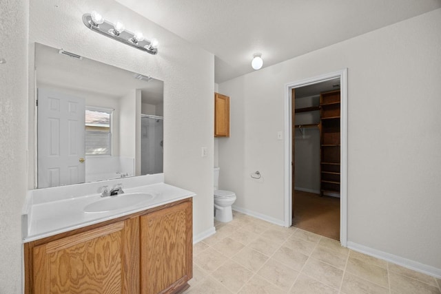 1444 Newbury St, Georgetown, TX 78626 - bathroom with vanity, an enclosed shower, toilet, a walk in closet, and baseboards