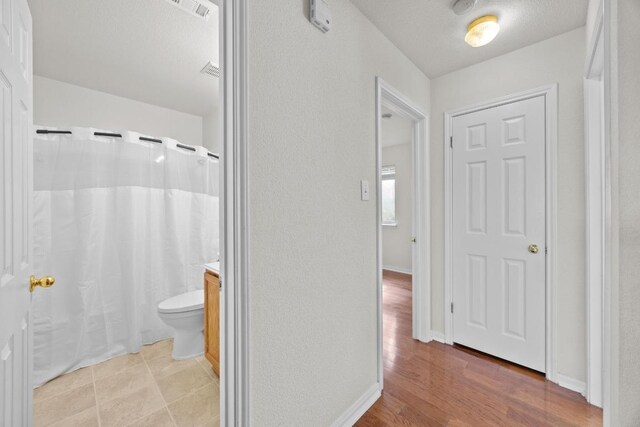 1444 Newbury St, Georgetown, TX 78626 - full bathroom with toilet, wood finished floors, and a textured wall