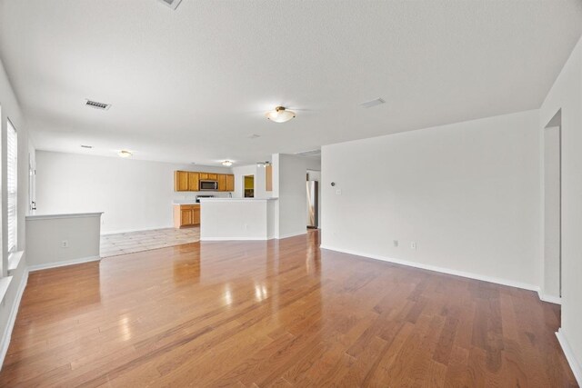 1444 Newbury St, Georgetown, TX 78626 - unfurnished living room featuring light wood-style floors and baseboards
