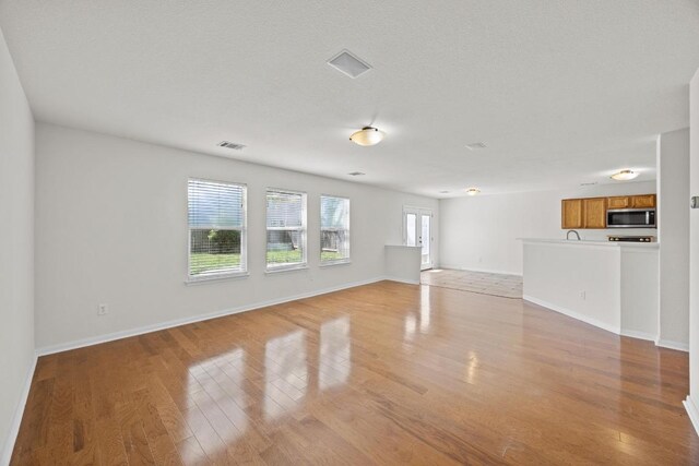 1444 Newbury St, Georgetown, TX 78626 - unfurnished living room featuring light wood finished floors and baseboards