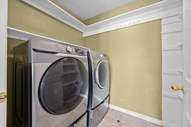 1444 Newbury St, Georgetown, TX 78626 - laundry area with a textured wall, washing machine and dryer, baseboards, tile patterned floors, and a textured ceiling