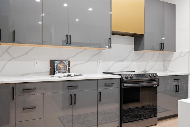 6002 Ponca St Unit 1, Austin, TX 78741 - kitchen with stainless steel electric range oven, gray cabinetry, modern cabinets, and tasteful backsplash