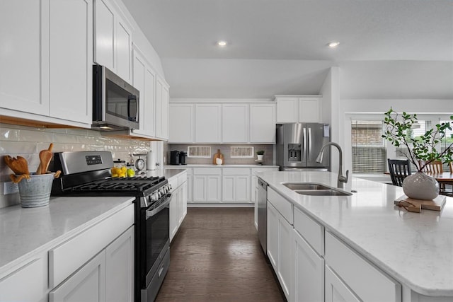 600 Spurlock Way, Liberty Hill, TX 78642 - kitchen with appliances with stainless steel finishes, vaulted ceiling, white cabinetry, decorative backsplash, and recessed lighting