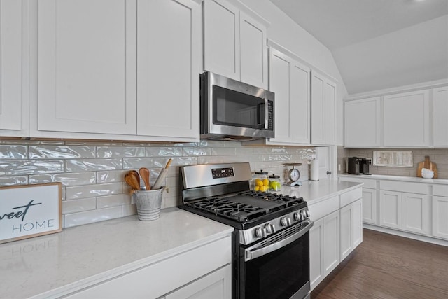 600 Spurlock Way, Liberty Hill, TX 78642 - kitchen featuring stainless steel appliances, vaulted ceiling, white cabinetry, decorative backsplash, and dark wood-style flooring