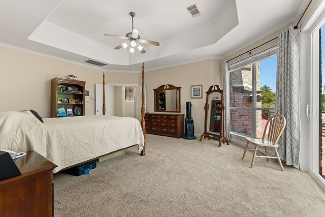 carpeted bedroom featuring a ceiling fan, crown molding, visible vents, and a raised ceiling