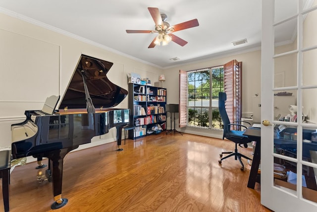 home office featuring wood finished floors, visible vents, crown molding, and ceiling fan