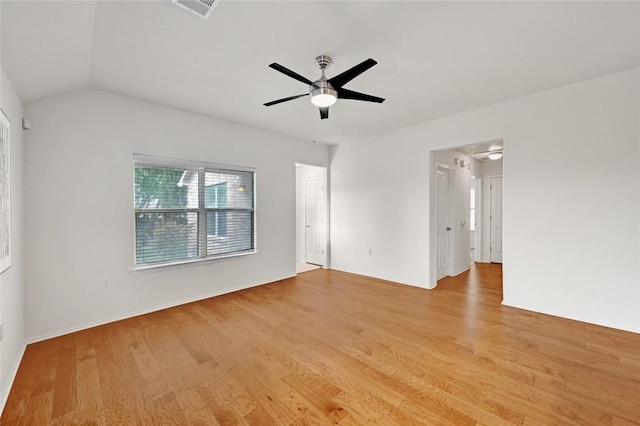 empty room with light wood finished floors, a ceiling fan, visible vents, and vaulted ceiling