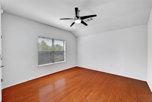 unfurnished room with lofted ceiling, wood finished floors, visible vents, and ceiling fan