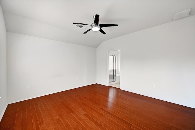 spare room with wood finished floors, a ceiling fan, visible vents, and vaulted ceiling