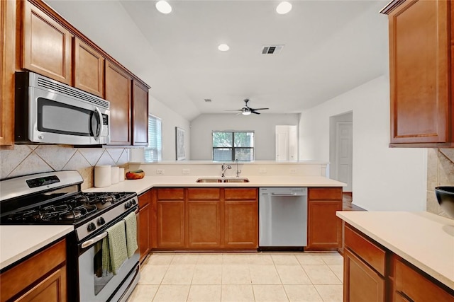 kitchen featuring stainless steel appliances, a sink, visible vents, backsplash, and light countertops