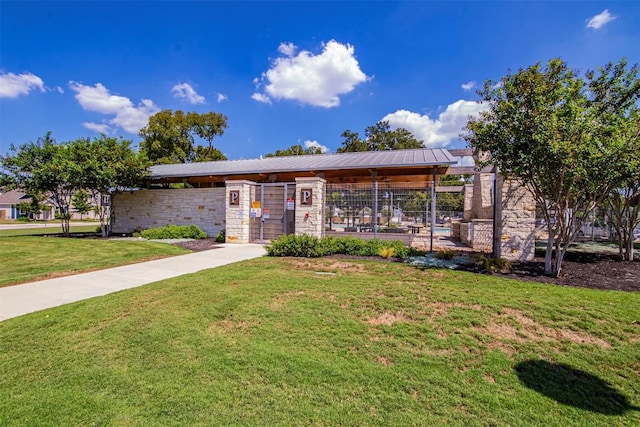 ranch-style home featuring stone siding, a front yard, and metal roof
