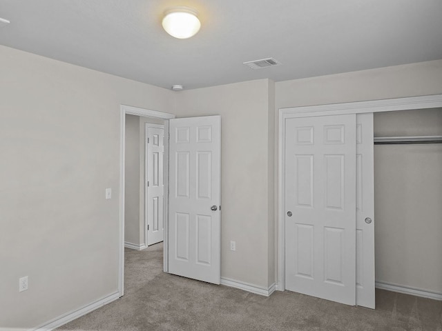 unfurnished bedroom featuring a closet, carpet floors, visible vents, and baseboards
