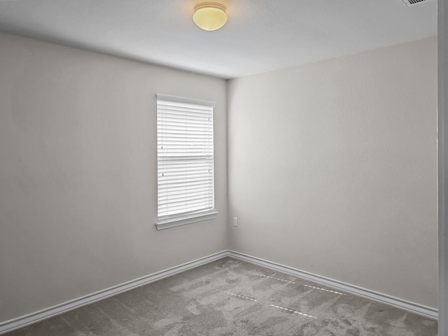 empty room featuring baseboards, a wealth of natural light, visible vents, and carpet
