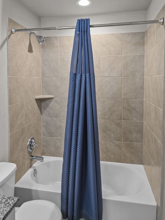 full bathroom with toilet and shower / tub combo with curtain