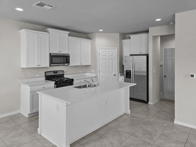 kitchen with visible vents, white cabinetry, stainless steel appliances, and a sink