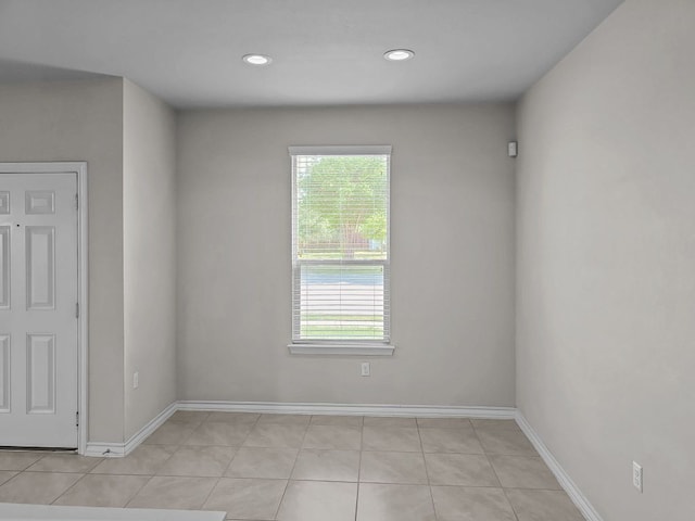 empty room with recessed lighting, baseboards, and light tile patterned floors