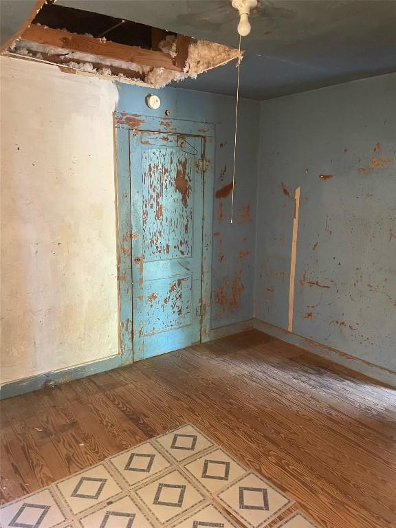 spare room featuring baseboards and wood finished floors