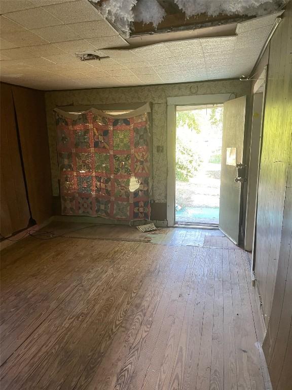 interior space with wood walls and hardwood / wood-style flooring