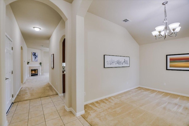 18301 Masi Loop, Pflugerville, TX 78660 - hallway featuring light carpet, lofted ceiling, arched walkways, a chandelier, and baseboards