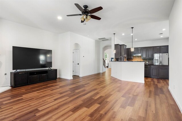 4817 Pyrenees Pass, Austin, TX 78738 - unfurnished living room featuring arched walkways, ceiling fan, wood finished floors, and recessed lighting